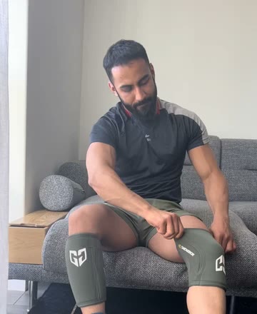 Moo on a sofa wearing knee sleeves